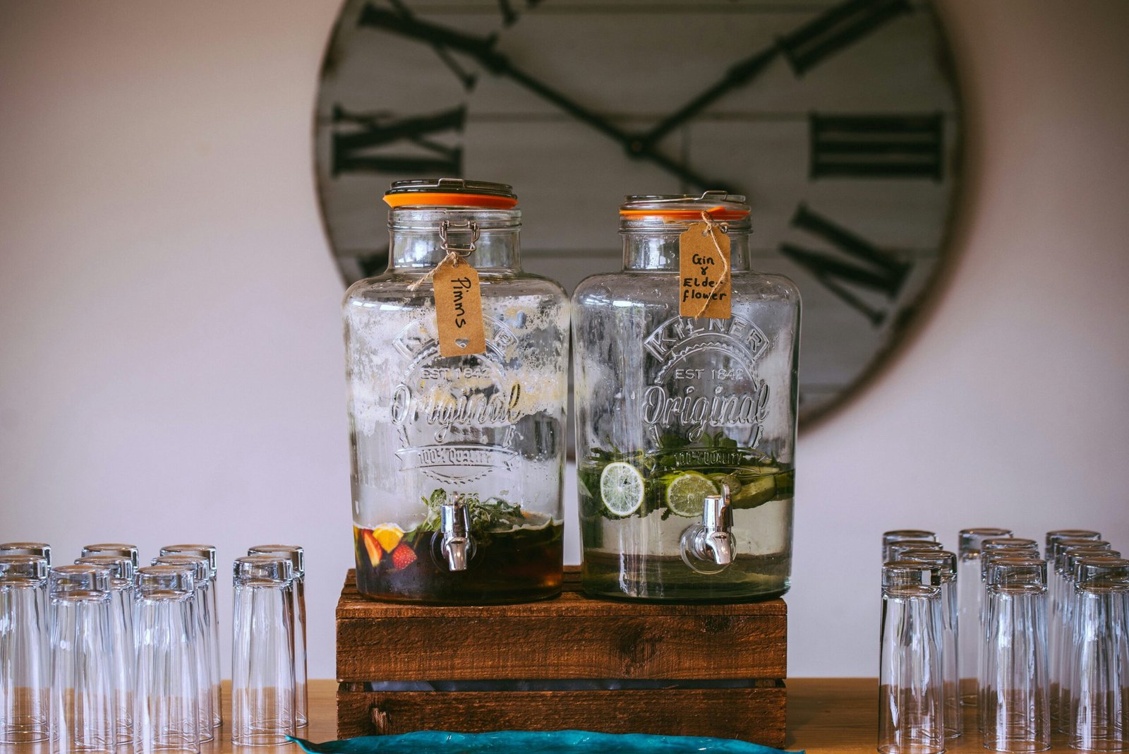 two glass beverage dispensers filled with sliced fruits on top of brown wooden rack